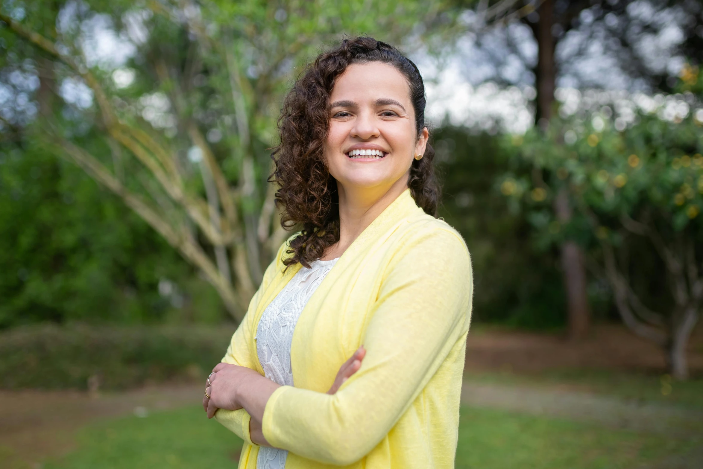 a woman with curly hair is smiling for the camera