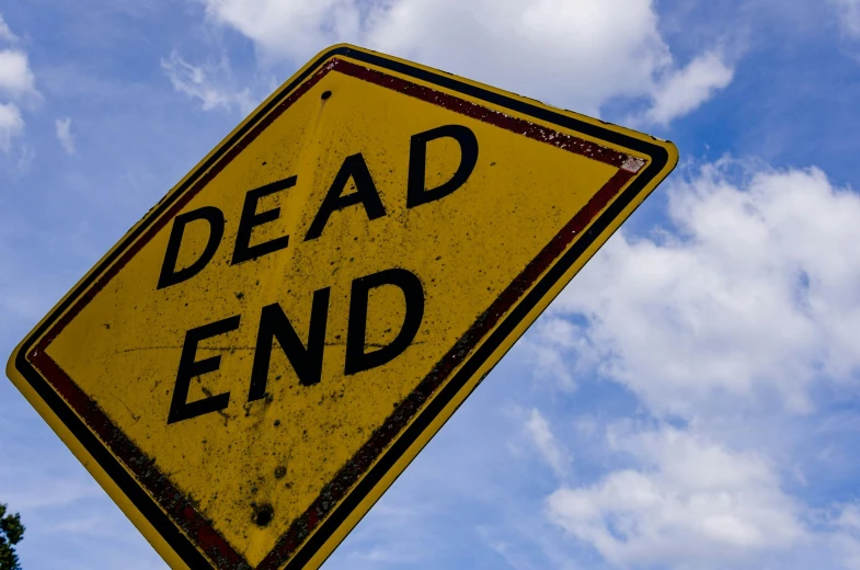 the sign reads dead end underneath a blue sky