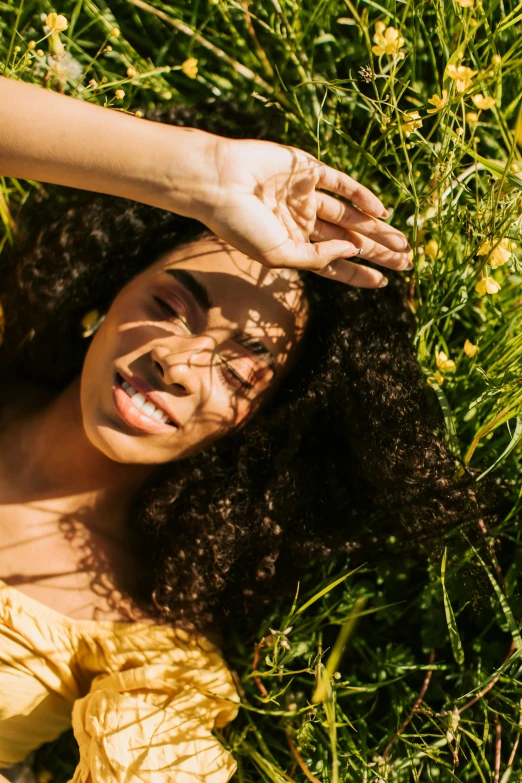 a woman in yellow dress laying on grass