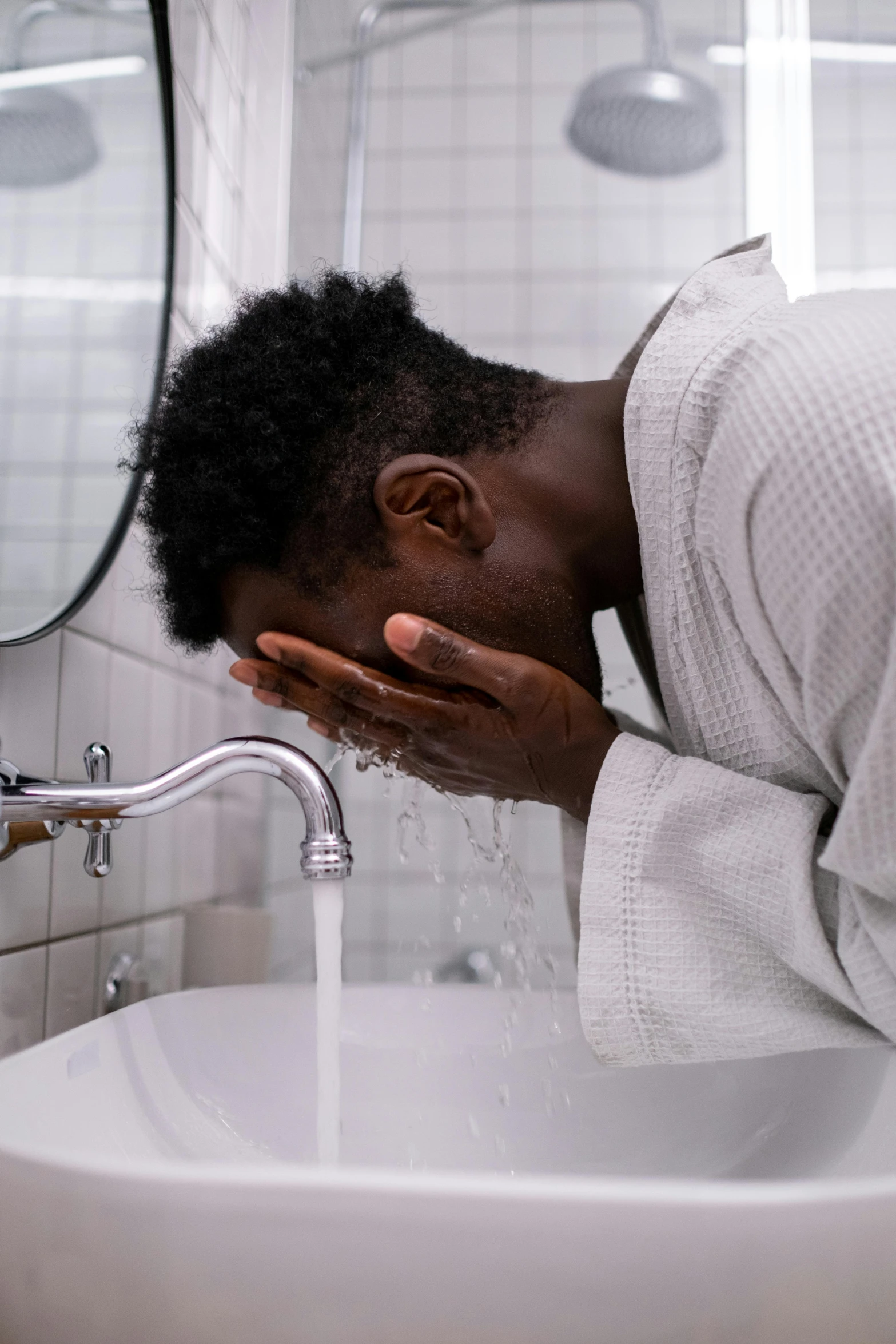 the man with his hand in the mouth is taking a drink