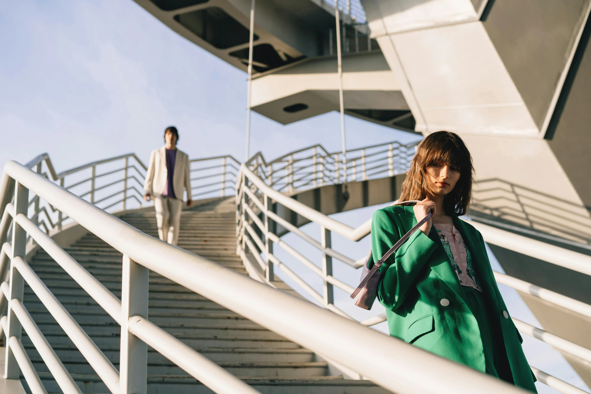 a woman walking down some stairs next to another person