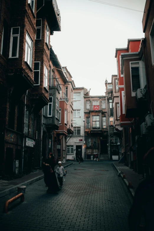 people walking in an alley with brick floors