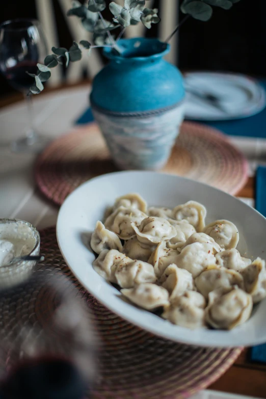 a white bowl with pasta and a side of dip