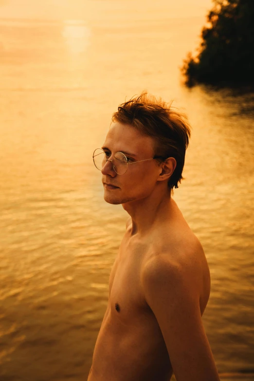 shirtless man at the edge of a body of water