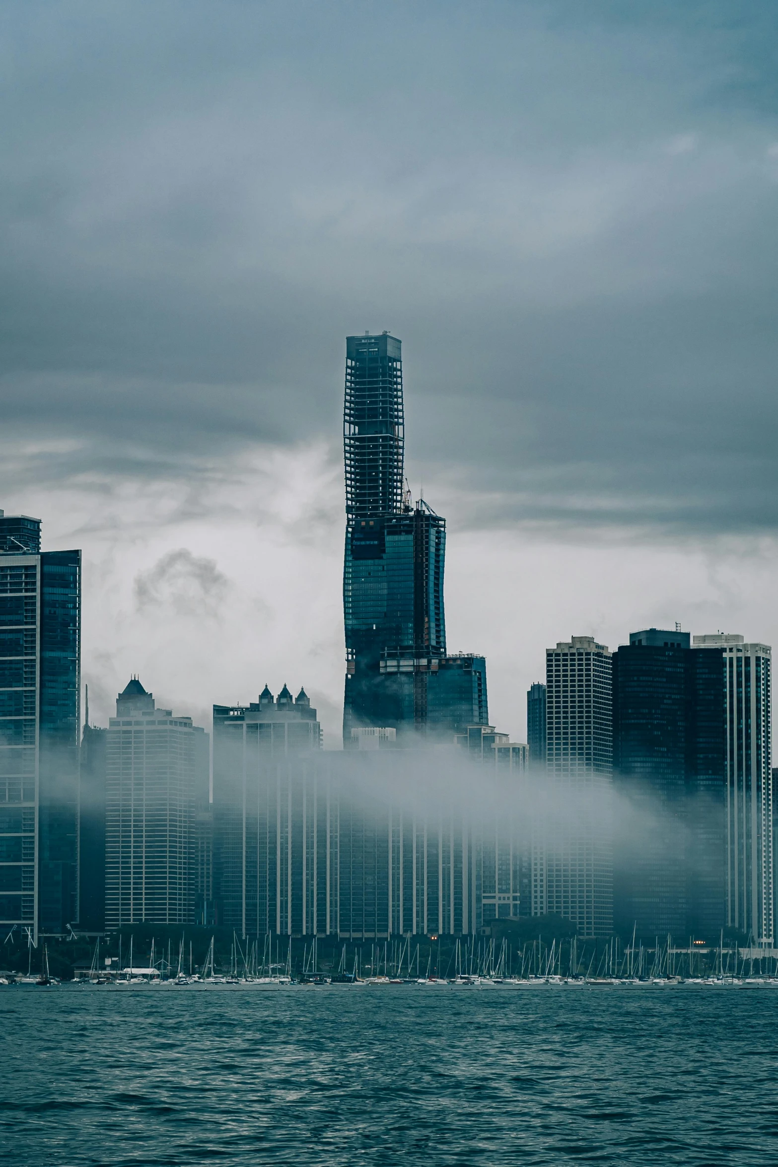 cityscape with water and fog in foreground on cloudy day