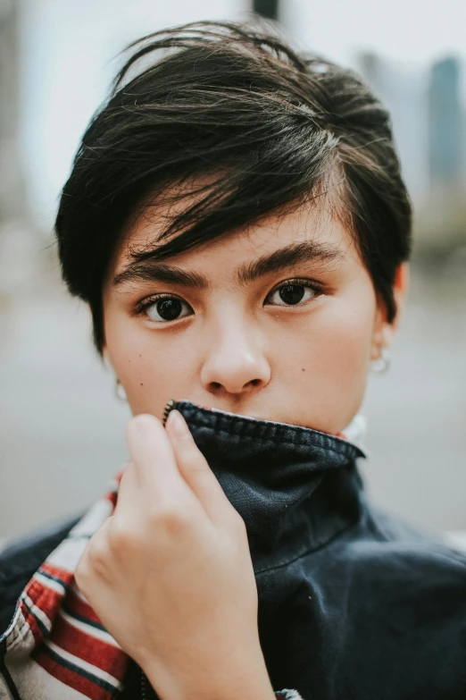 a girl with a jacket on is pulling the ends of her tie