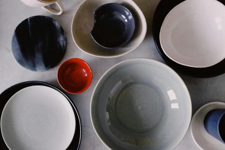 a table with different colored plates and bowls on it