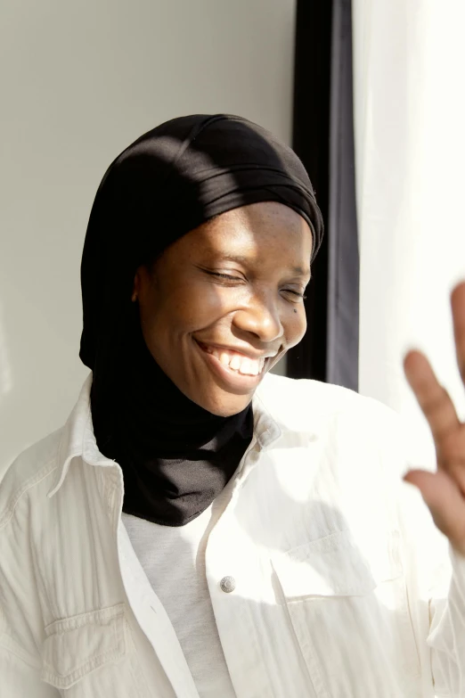 a smiling woman wearing a headscarf smiles