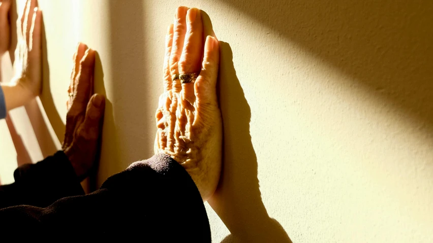 a woman's hands with food hanging from a wall