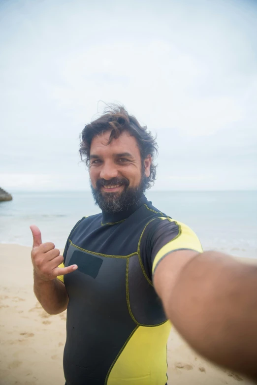 a guy posing for a picture with another person on the beach