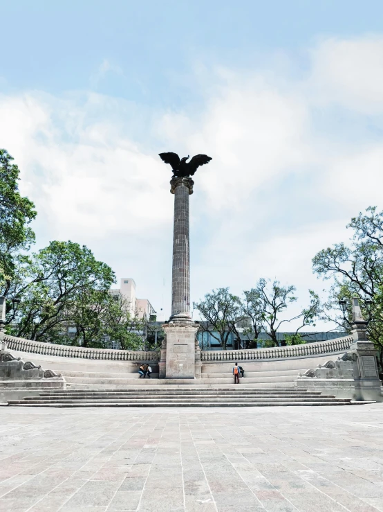 a statue sitting in the middle of a public park