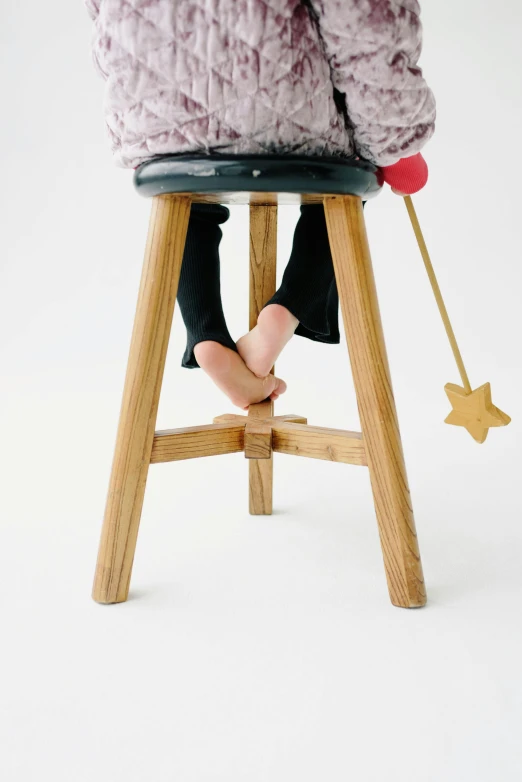 someone wearing winter clothes standing on a stool