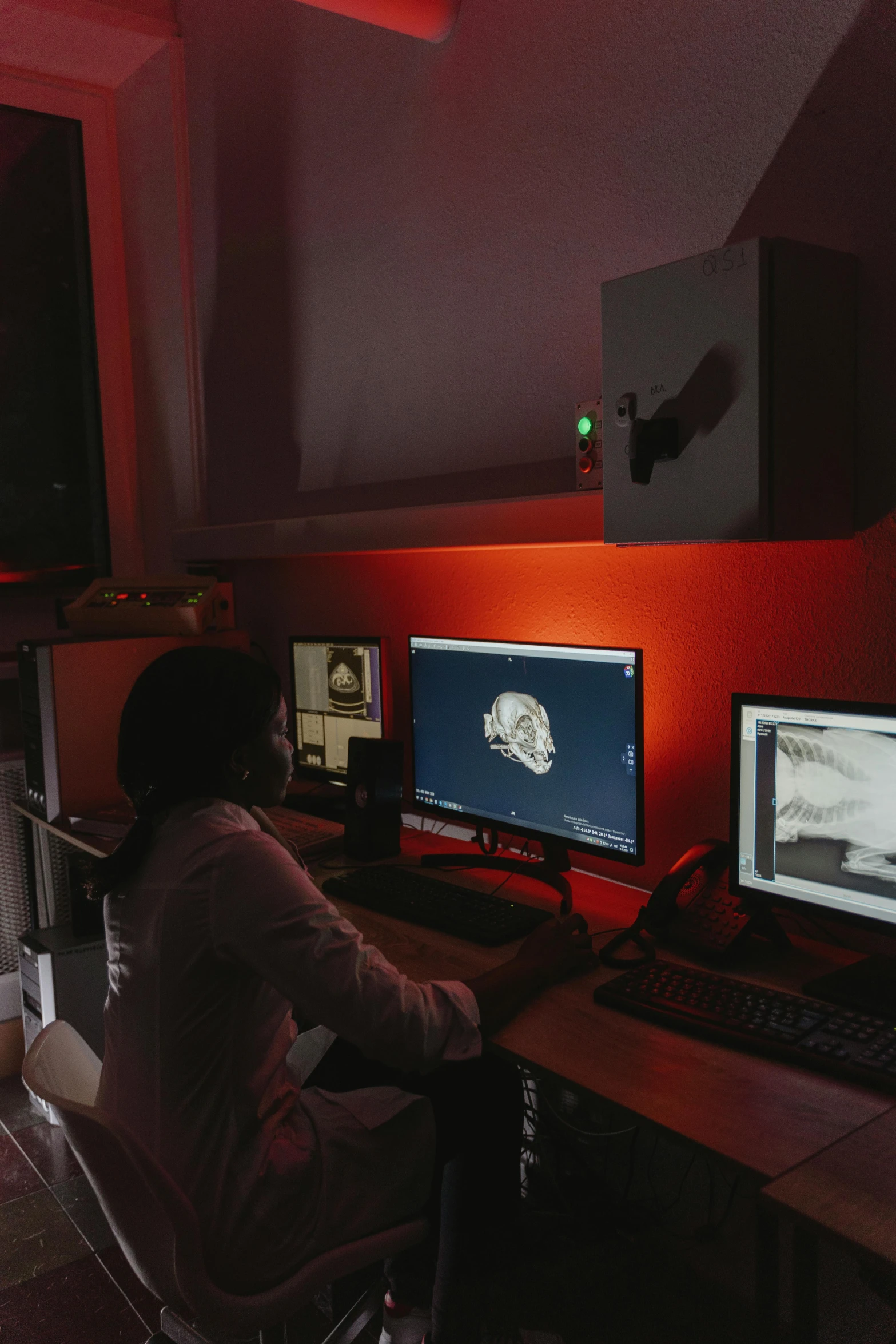 a person sitting in front of two monitors on computer desk