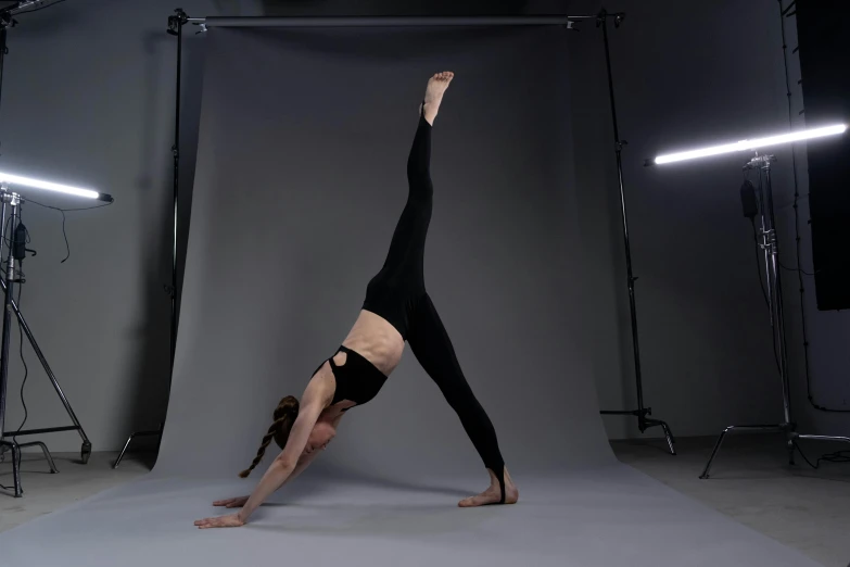 a person performing a handstand in the middle of a studio