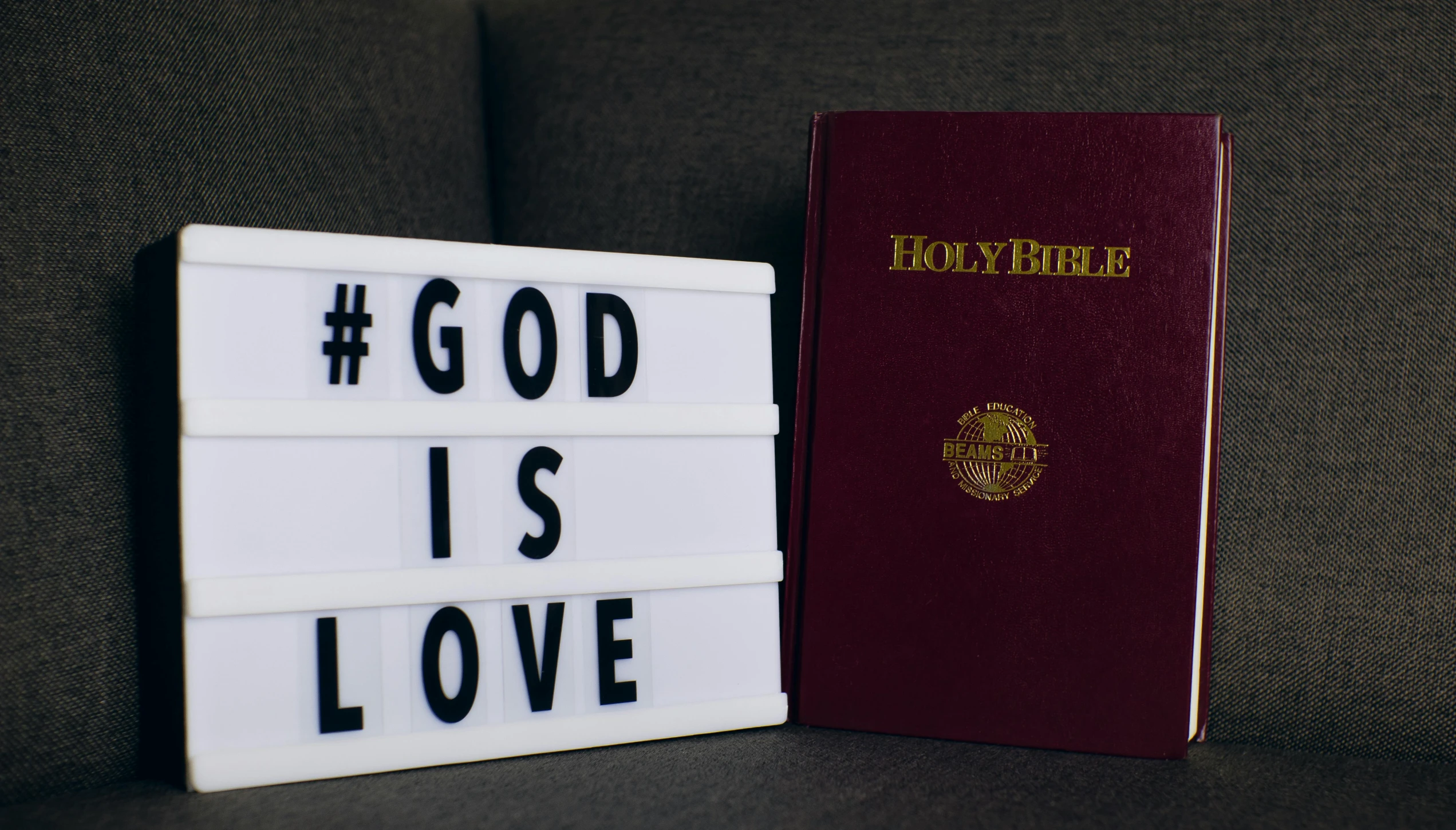 a white light up sign with black lettering that says god is love