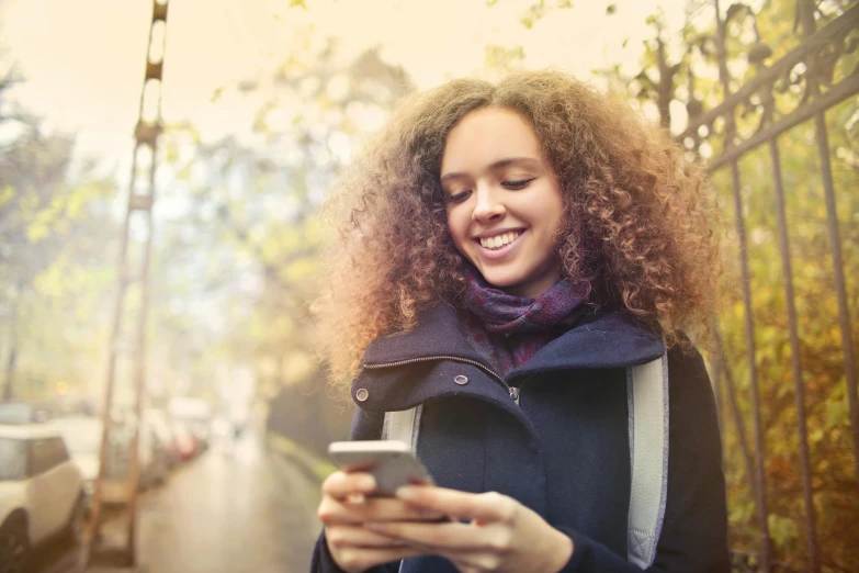 a person standing by the street with a cell phone