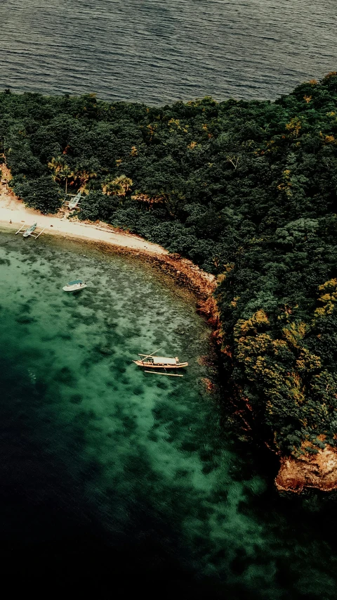 two boats in the water next to a beach