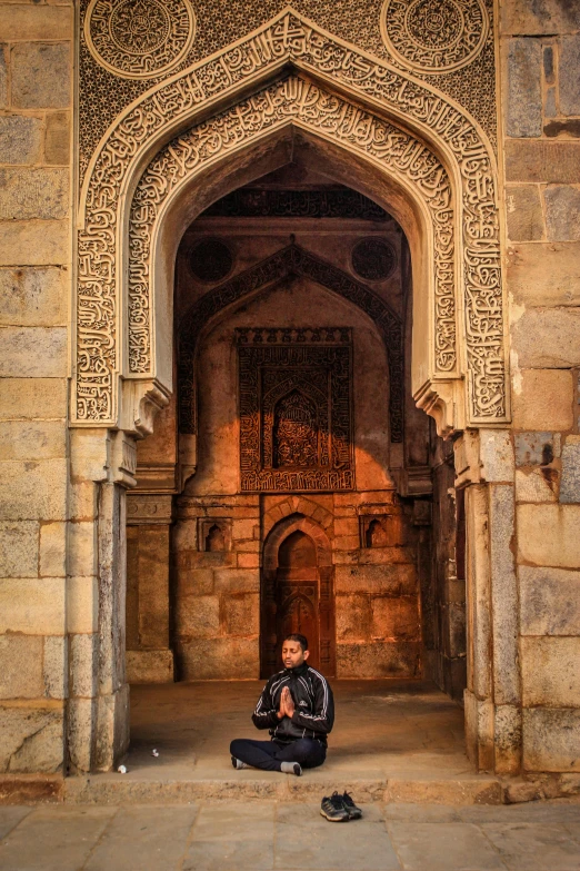 a man sitting under an arch in a doorway