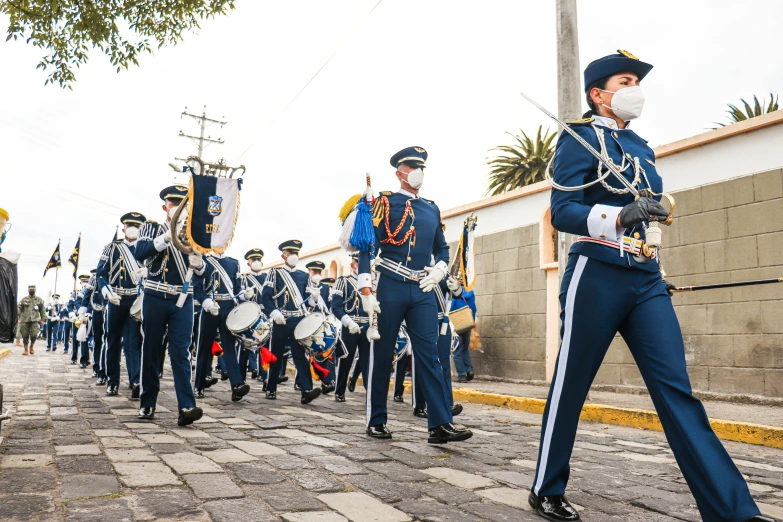 a man with a face mask walking in front of a marching band