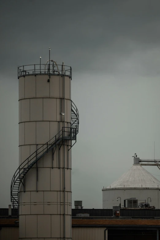 a factory with metal tanks and a clock on the side