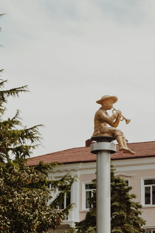 two statues sit on top of a pole