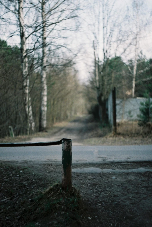 the rusted post on the side of the road has a stop sign