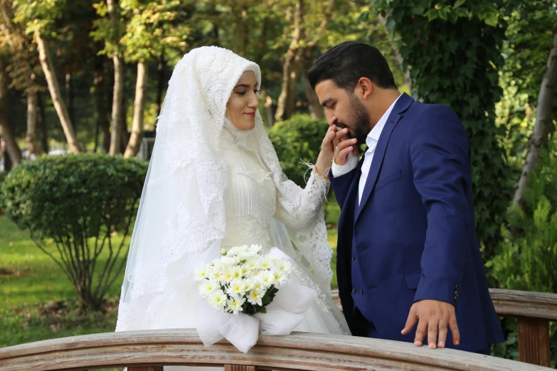 a bride and groom are posing for a picture on a bench