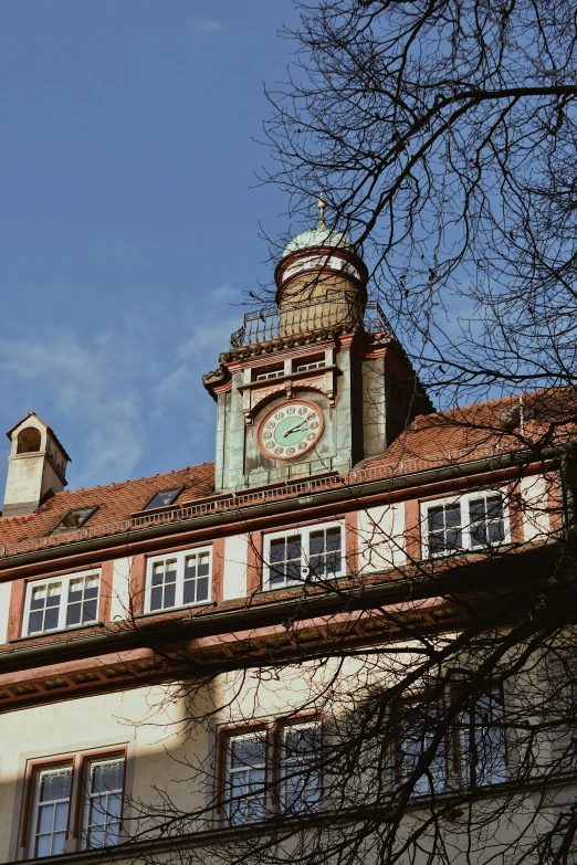 the building with the clock tower is surrounded by trees