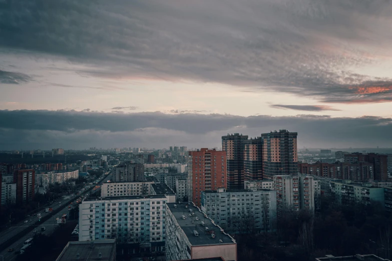 storm clouds above buildings and trees with a city in the foreground