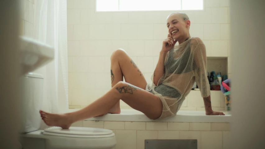 a woman on the phone sitting in a bath tub