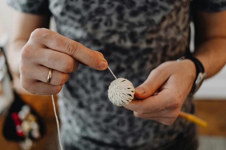 a woman stringing soing with string and pulling it with her fingers