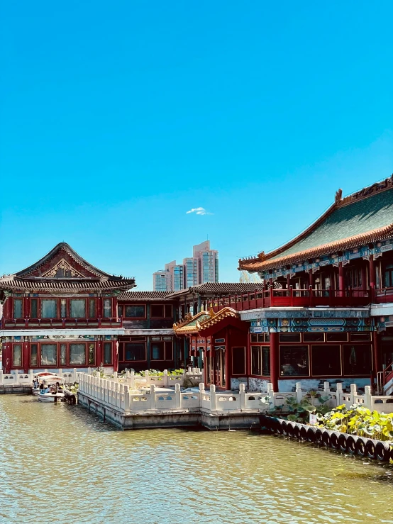 an asian building next to water on a sunny day