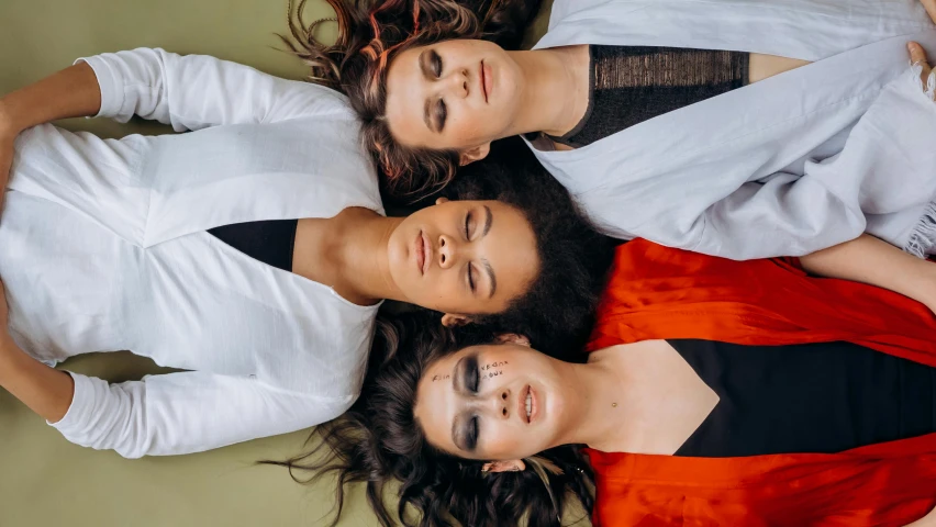 three young women smile brightly in an aerial pograph