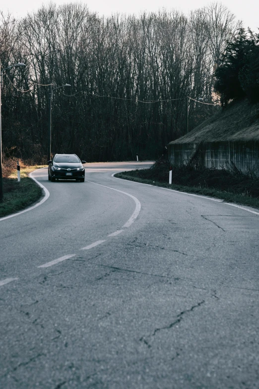 car driving down a curved road on a hill