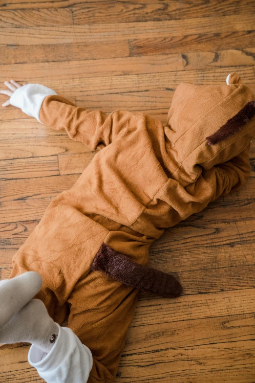 a doll laying on the floor wearing a costume