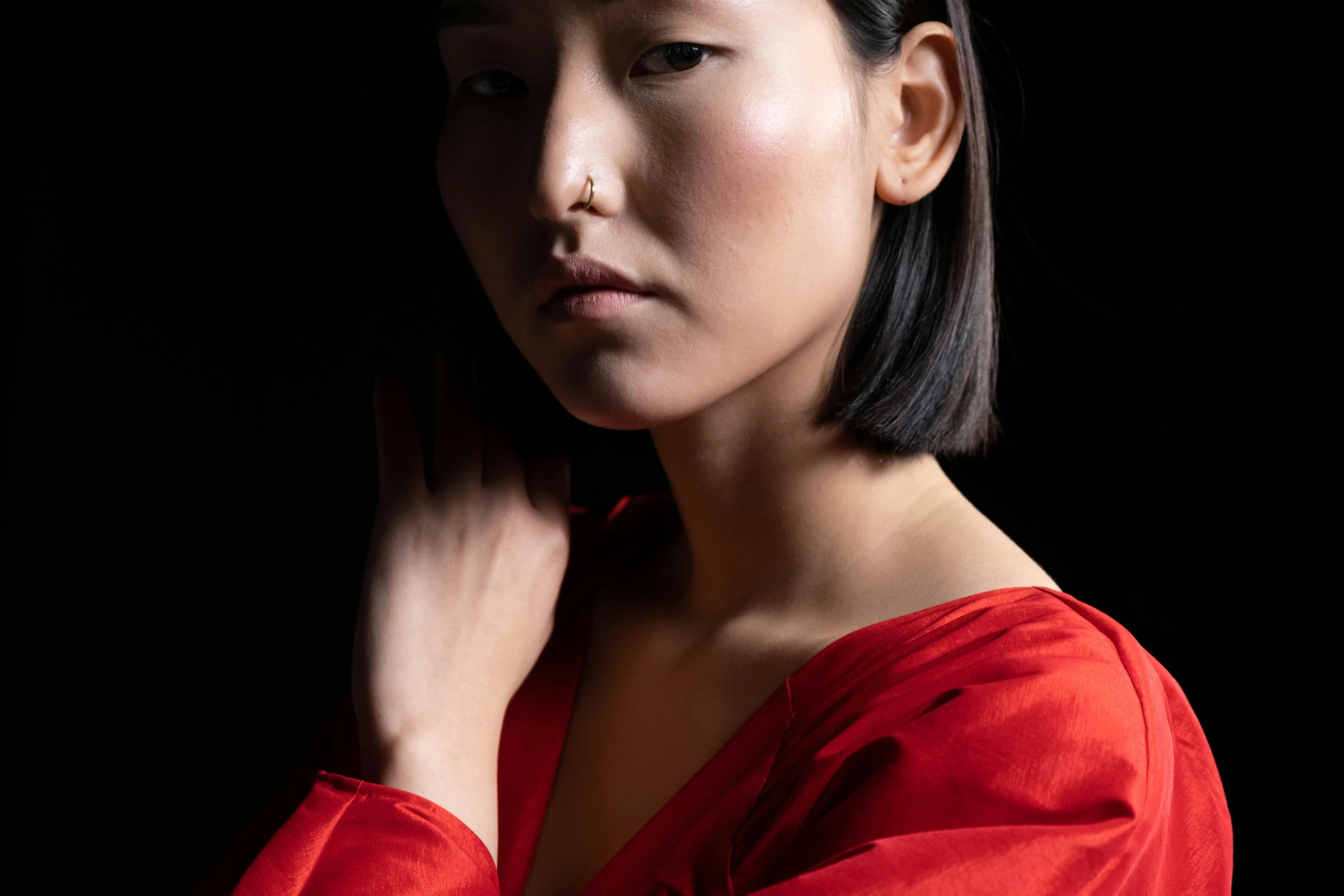 an asian woman in a red dress looks away