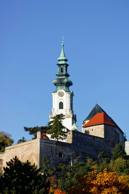 a clock tower stands at the top of a stone hill