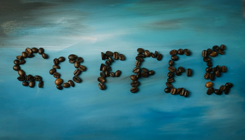 a blue table with coffee beans spelling out the words fix