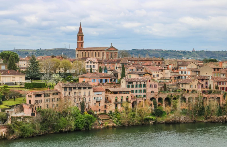 a town by the river with an old church on top