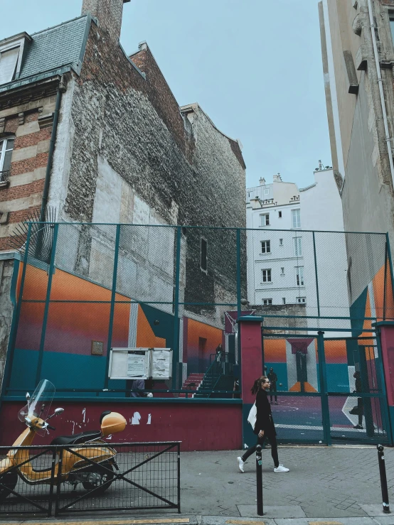 people walking near a fenced in area of an old city