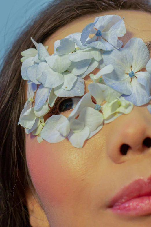 a woman with blue eyes and white flowers on her face