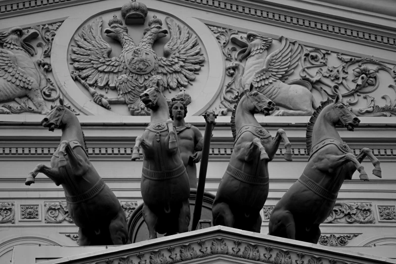 two statues of four horses near a decorative sculpture