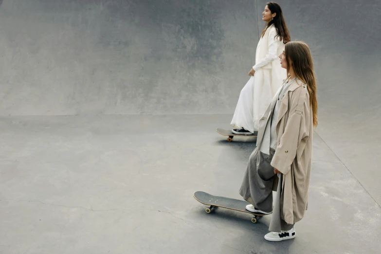 two girls dressed in white are skateboarding on their skate boards