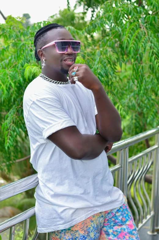 a man smoking on a fence next to some trees