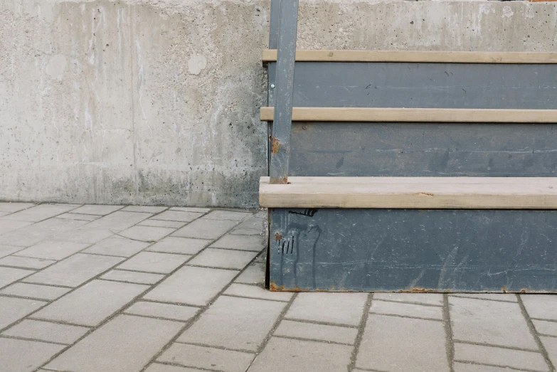 there is an old, worn wooden bench next to a stone wall