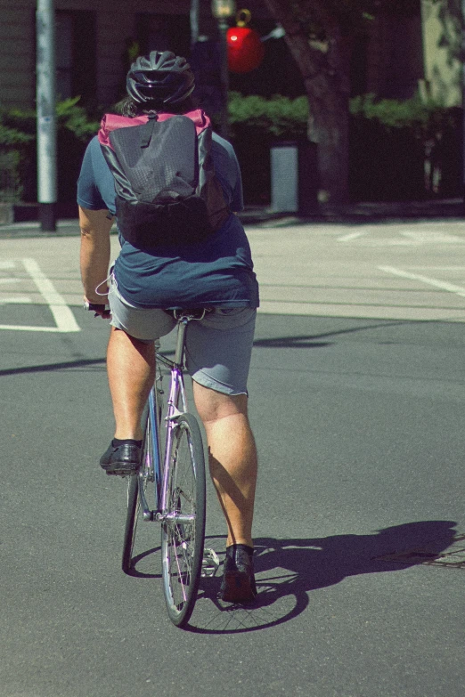 a person wearing a backpack rides a bike
