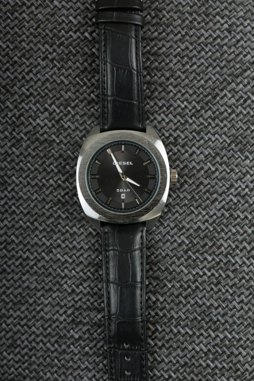 a watch that is laying on top of some black fabric