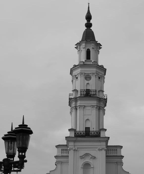 a church steeple and a street light with a cloudy sky