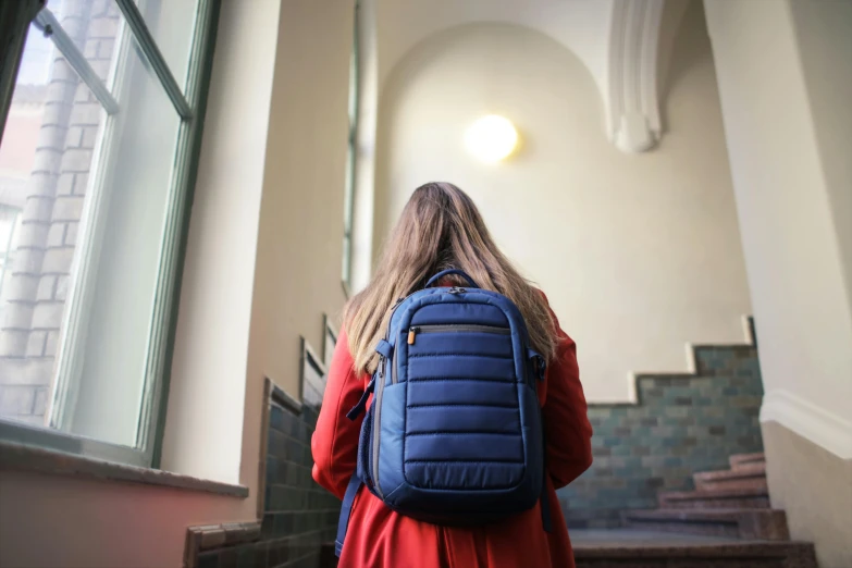 a female with a blue backpack and a red dress