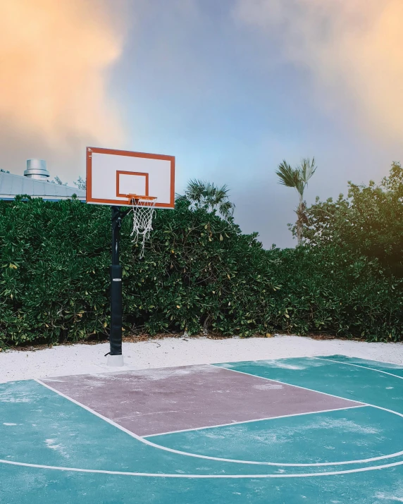 basketball hoop above basketball court on a cloudy day